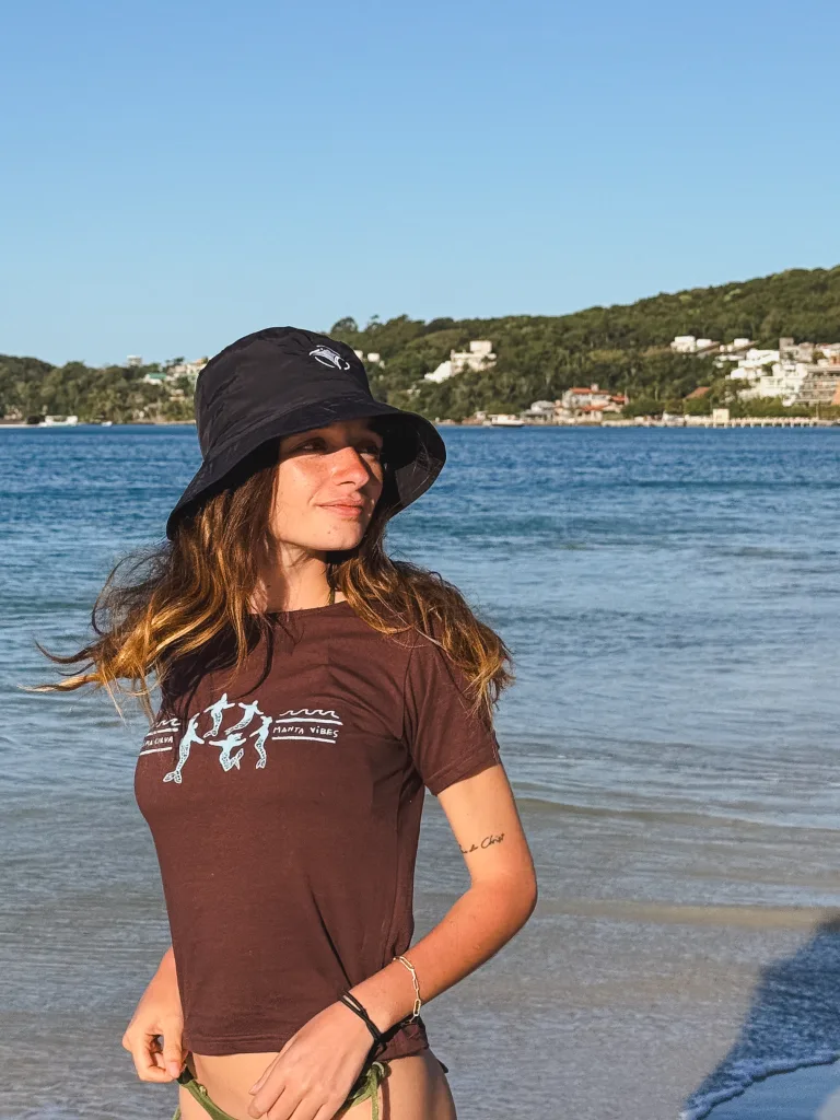 Remera marrón de Alma Curva y Manta Vibes con los buzos, puesta frente al mar