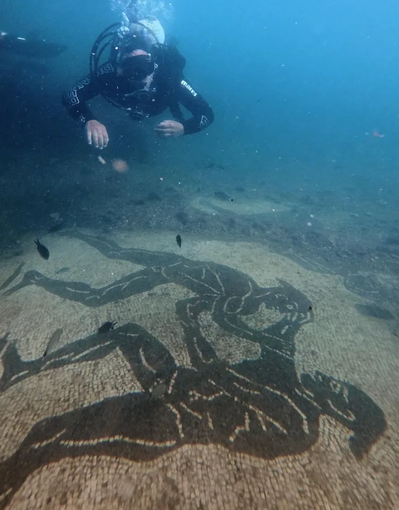 Buzo nadando sobre un gran mosaico romano en el Parque Arqueológico Sumergido de Baia