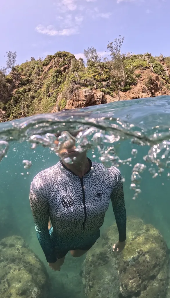Luz nadando entre las rocas de Búzios, mitad dentro y mitad fuera del agua