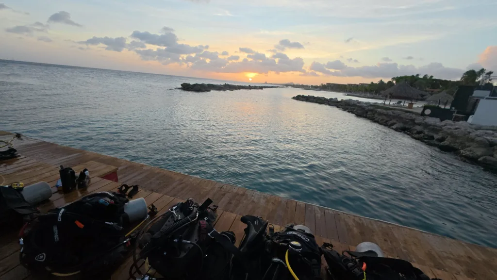 Atardecer sobre el mar en Curaçao, visto desde un muelle con equipos de buceo
